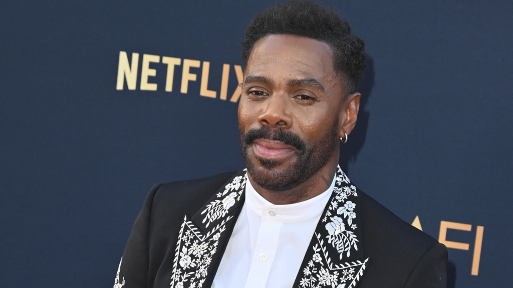 Colman Domingo smiles, wearing a black suit with white floral embroidery and a white shirt, against a dark background with "NETFLIX" and "AFI" logos.