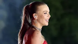 UK singer Becky Hill side profile looking to the right with a big smile.