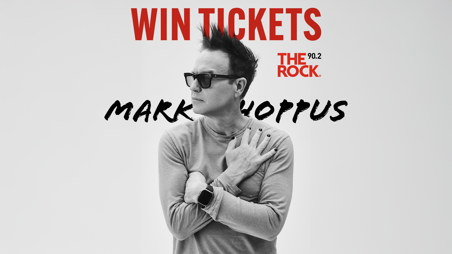 A greyscale image of Mark Hoppus wearing sunglasses, a grey shirt, and black nail polish, with his arms crossed. Red text reads "WIN TICKETS" and "THE 90.2 ROCK", with "MARK HOPPUS" in black script.