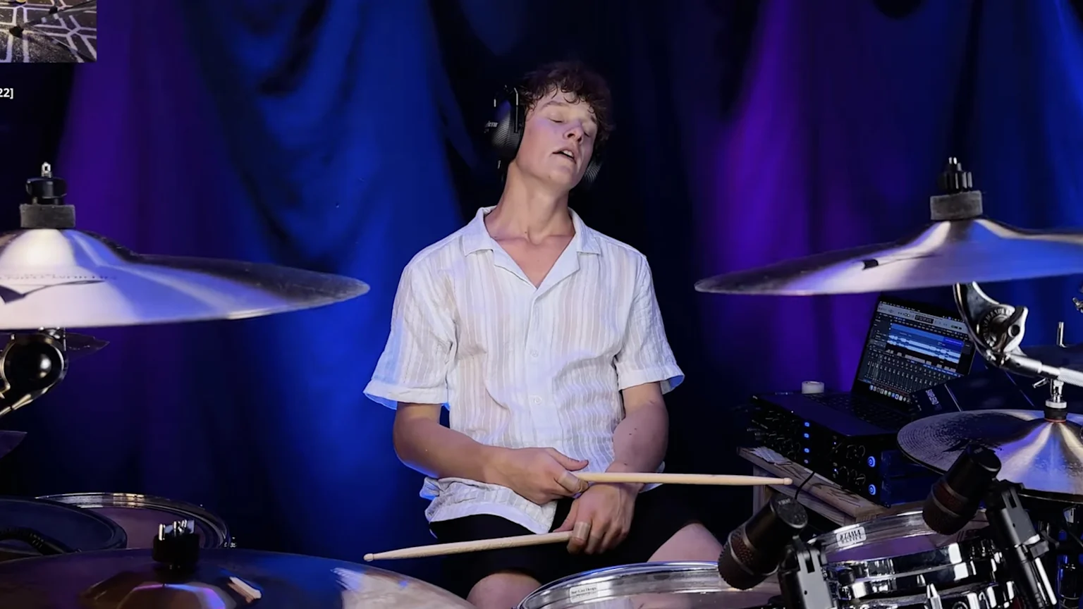 boy looks exhausted at drum kit.