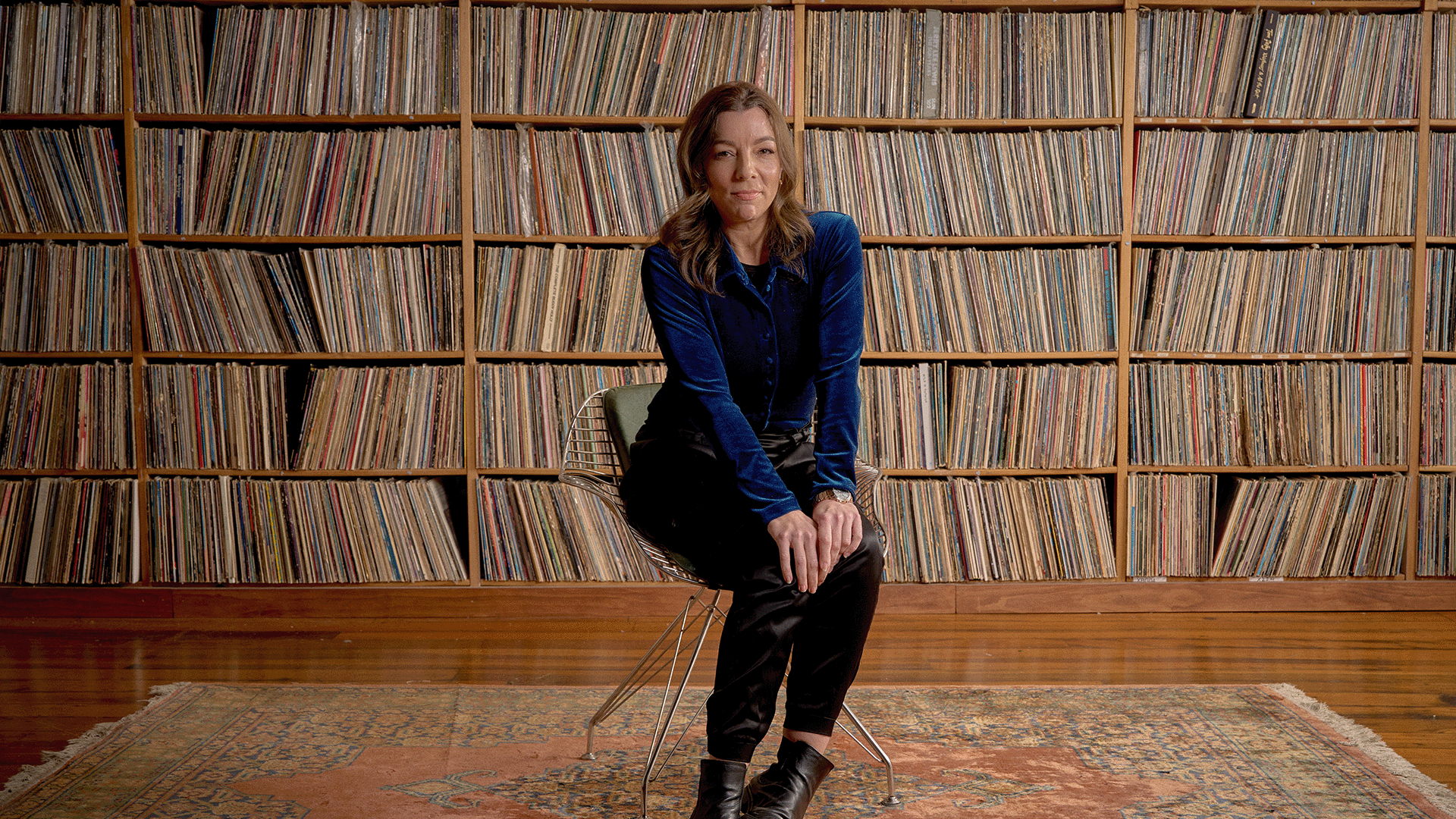 Georgia Cubbon sits in front of vinyl record collection