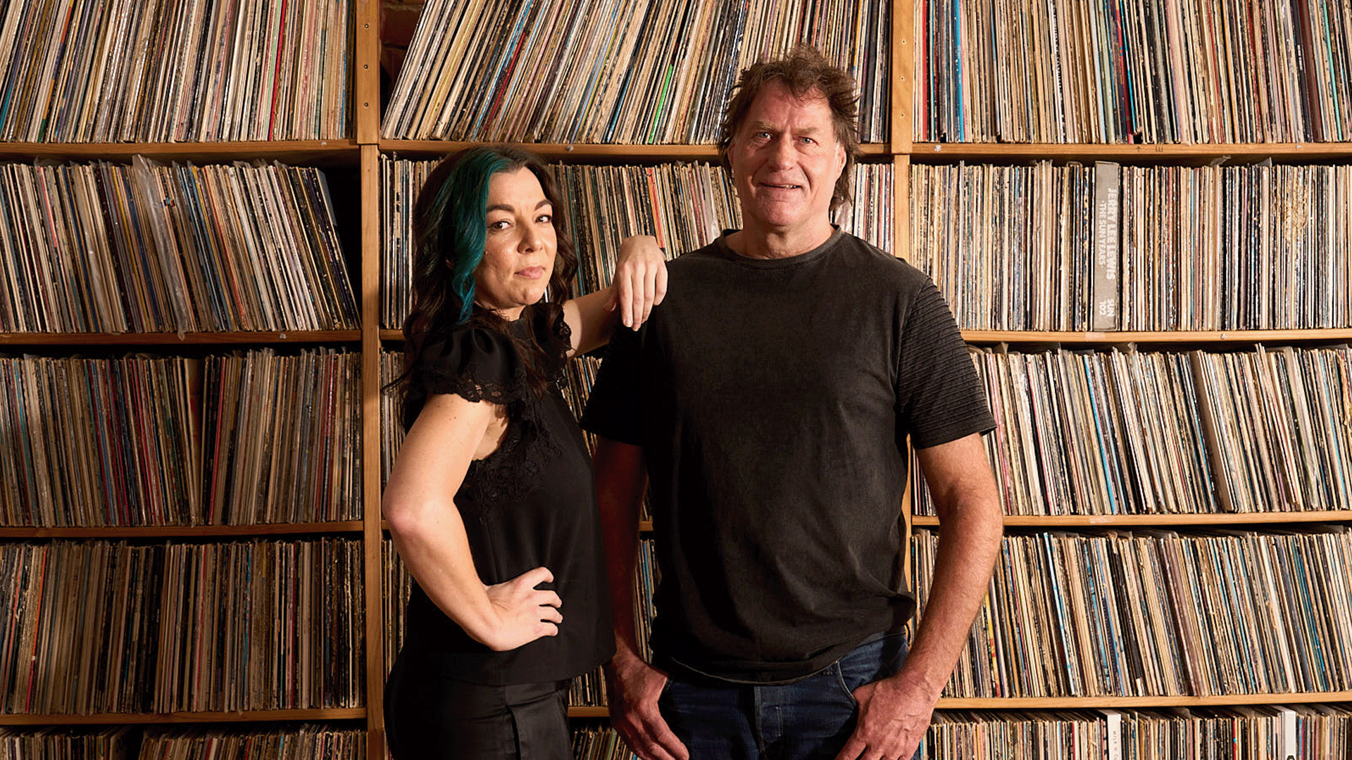 Georgia Cubbon & Robert Taylor pose in front of vinyl record collection