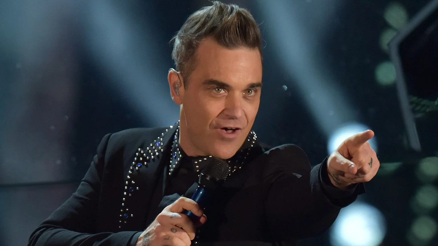 Robbie Williams performing on stage