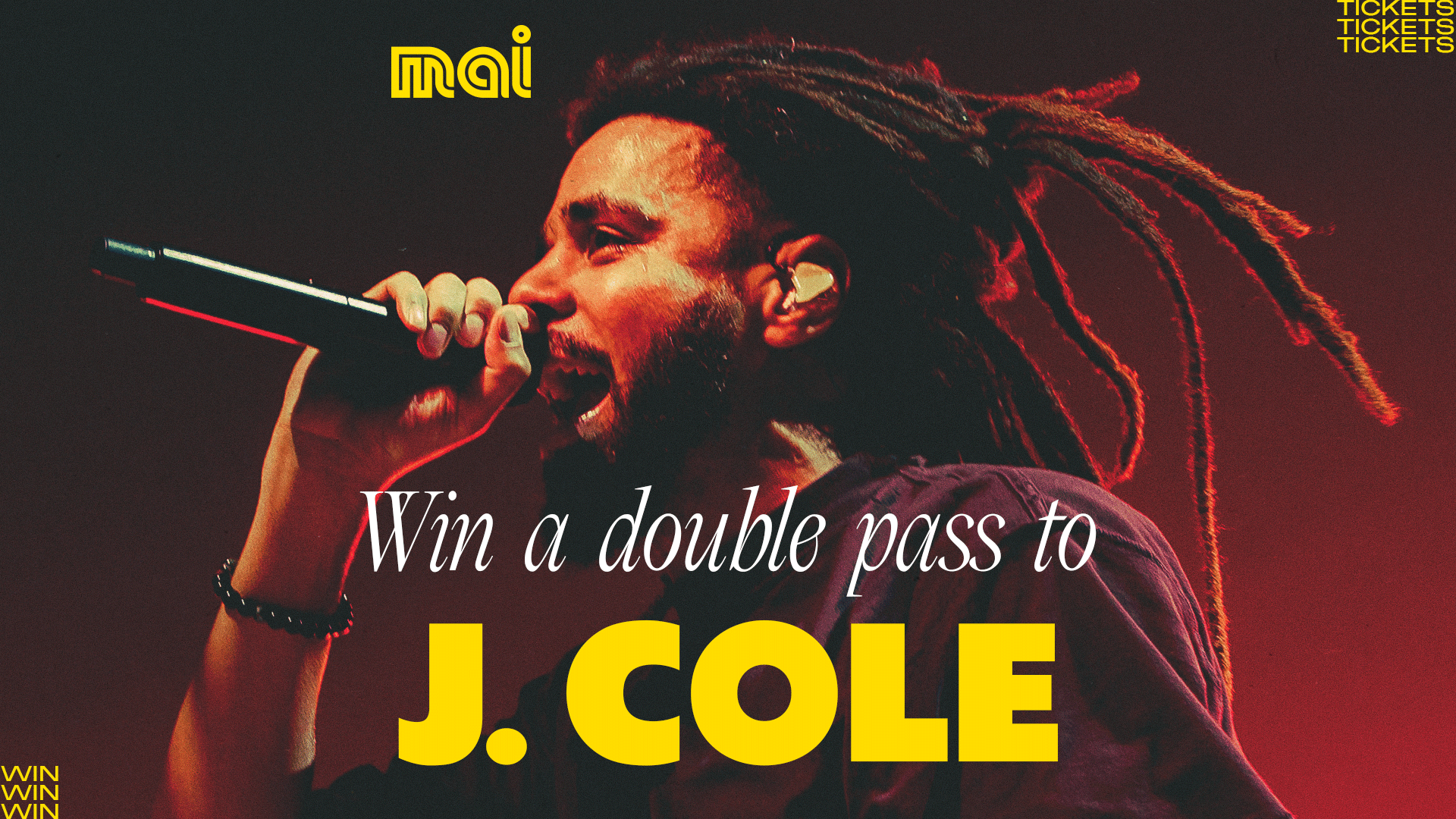 J. Cole, a man with dreadlocks and a beard, sings passionately into a microphone under red stage lights, with text advertising a "Win a double pass to J. COLE" giveaway.
