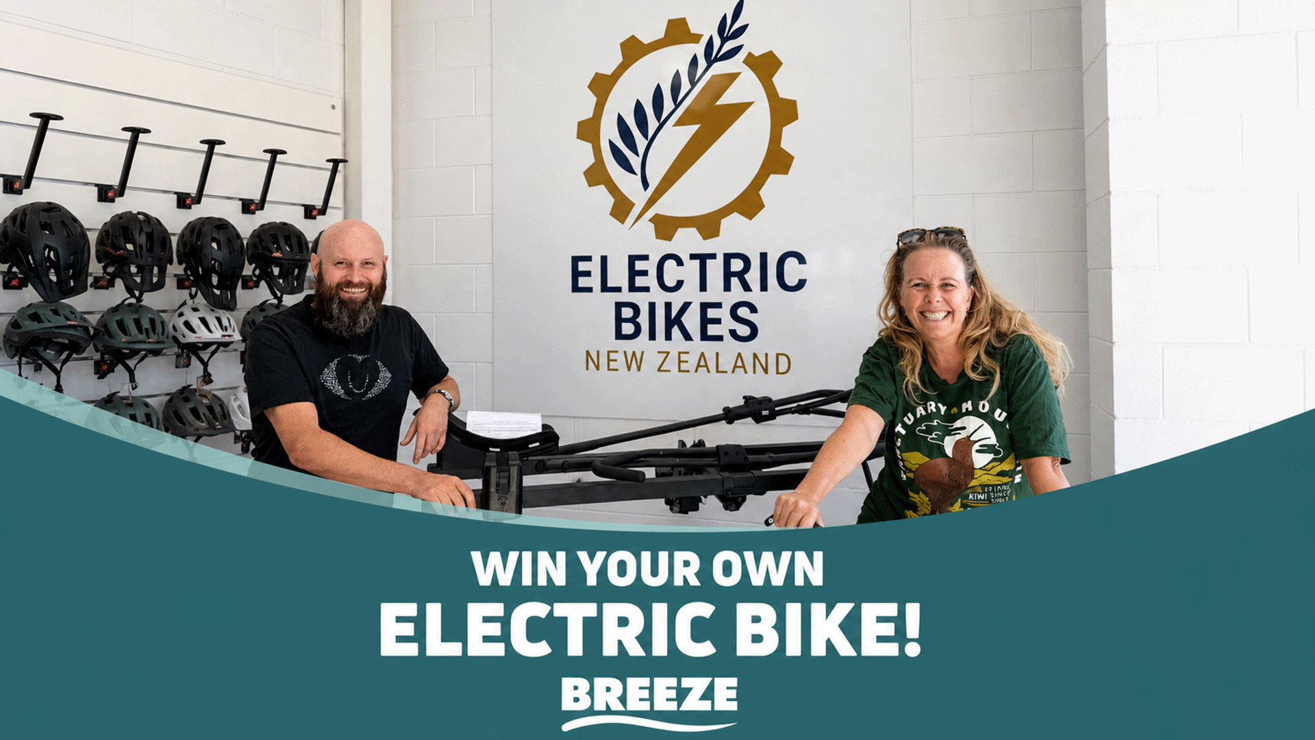 A smiling man and woman stand in an electric bike shop with helmets, an "Electric Bikes New Zealand" sign, and text announcing "WIN YOUR OWN ELECTRIC BIKE!".