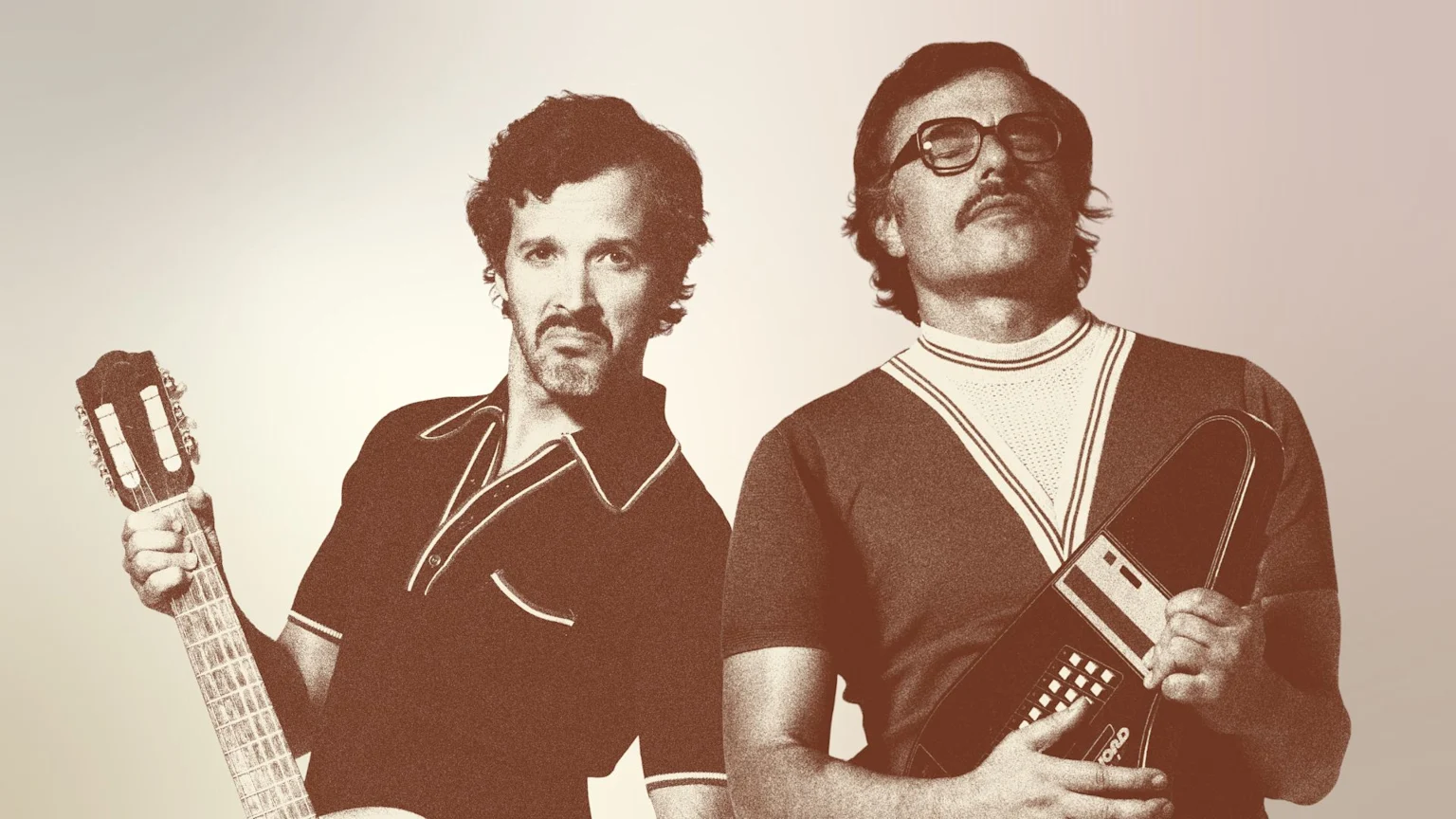 Sepia-toned image of two men: the left man with a mustache and beard holds a classical guitar; the right man with glasses and a mustache holds a vintage electronic device.