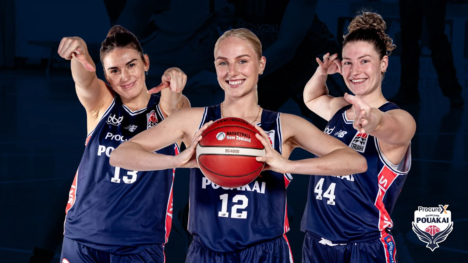 Three smiling women basketball players in dark blue "Pouākai" jerseys pose, with the middle player holding a basketball, against a dark blue background with silhouettes.