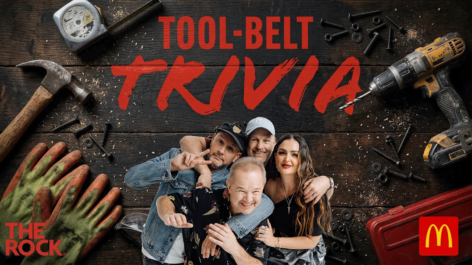 Four smiling people pose under prominent red text "TOOL-BELT TRIVIA", surrounded by various construction tools like a hammer, drill, screws, gloves, and a tape measure on a dark wooden background, with "THE ROCK" and McDonald's logos.