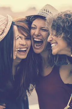 Four friends laughing together outdoors