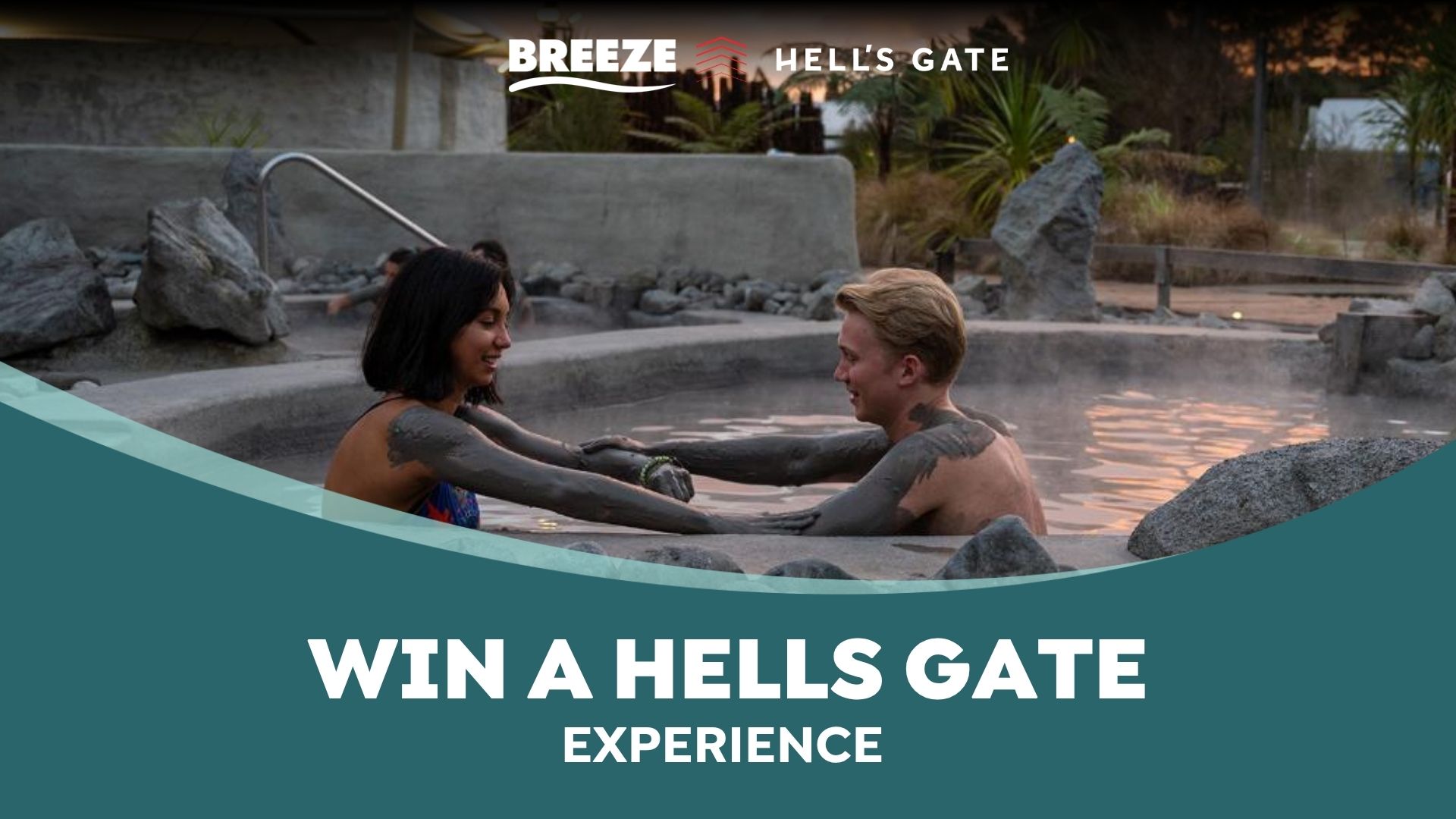 Two smiling people covered in mud relax in a steamy outdoor thermal pool, surrounded by rocks and plants, with 'Breeze', 'Hell's Gate' logos, and 'Win a Hells Gate Experience' text.