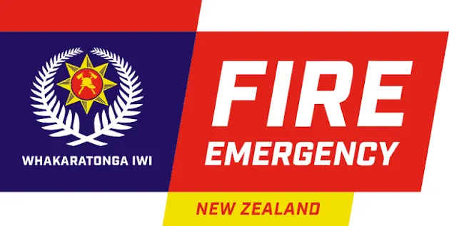 A banner with a blue left side featuring a star and laurel wreath logo above "WHAKARATONGA IWI", and a red right side with "FIRE EMERGENCY" above "NEW ZEALAND" on a yellow stripe.
