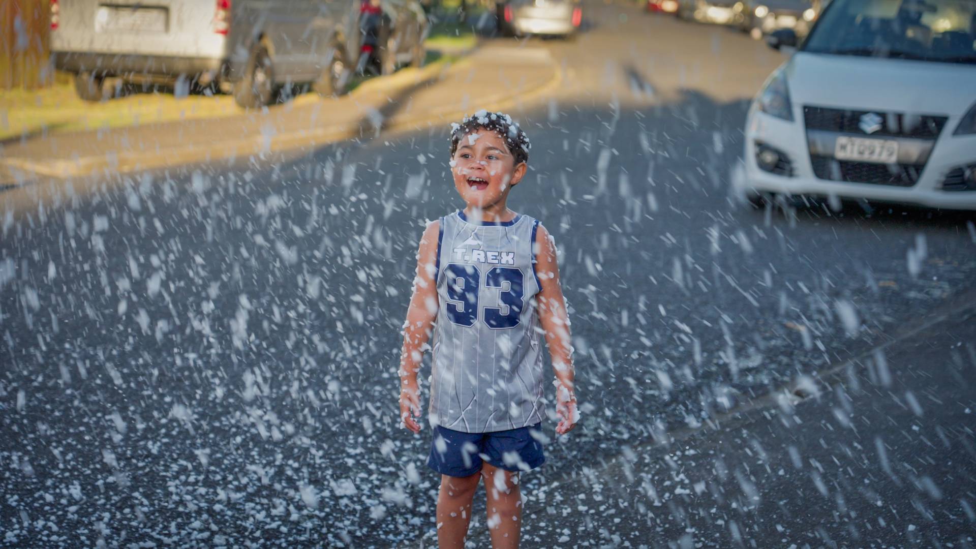 A child plays in fake snow at the Otara Xmas lights celebration. 