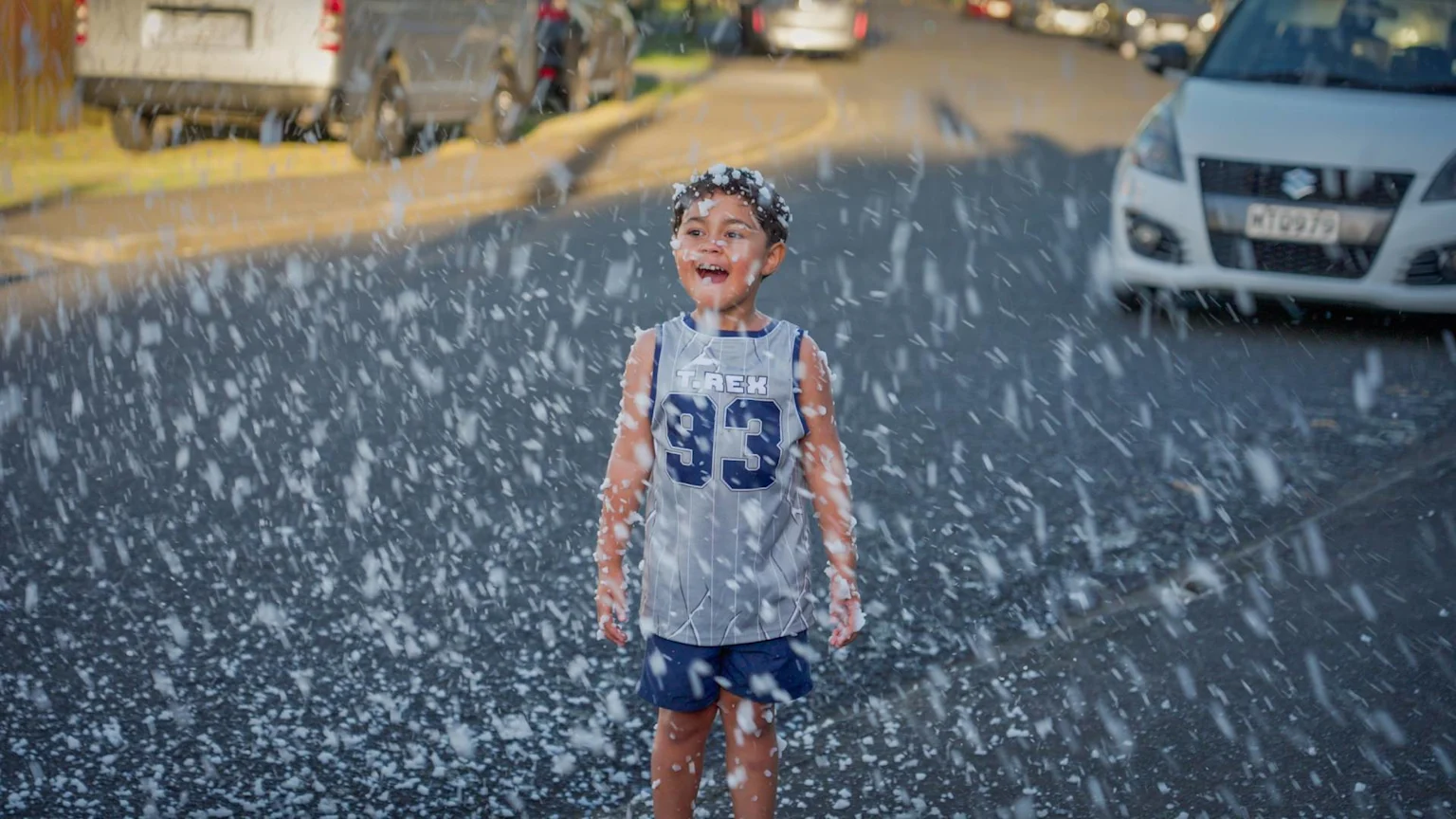 A child plays in fake snow at the Otara Xmas lights celebration.