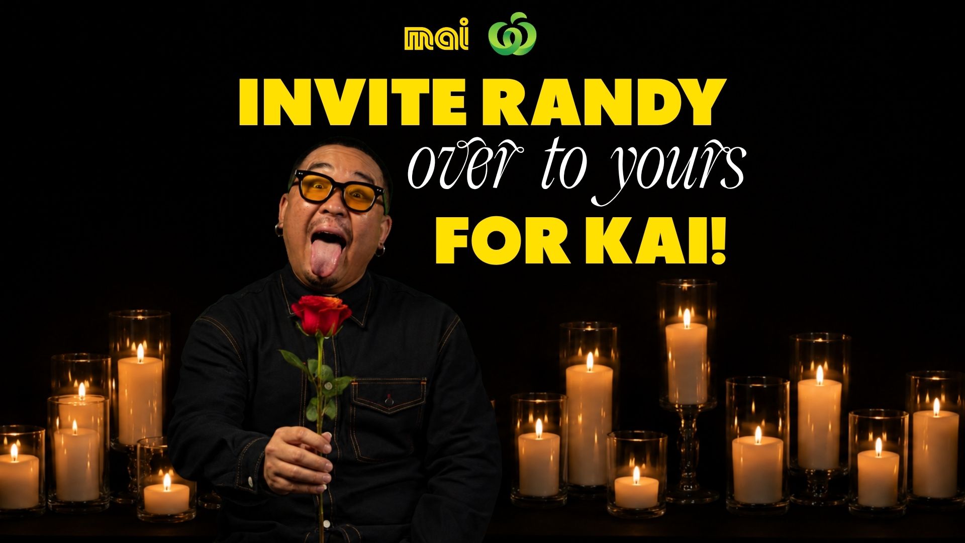 A man wearing yellow glasses with his tongue out, holding a red rose, stands amid many lit candles against a dark background, with the text "INVITE RANDY over to yours FOR KAI!" and the Mai and Woolworths logos above.
