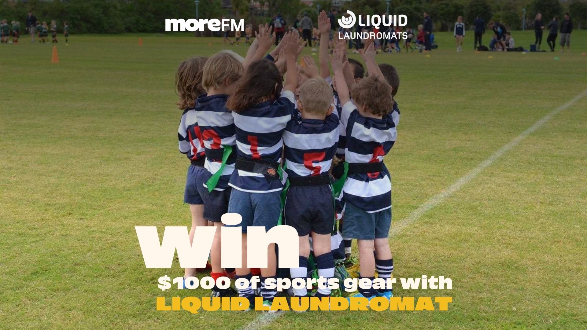 A youth sports team in striped jerseys and flag belts huddles on a grass field, with "moreFM" and "LIQUID LAUNDROMATS" logos and a "win $1000 of sports gear" promotion.