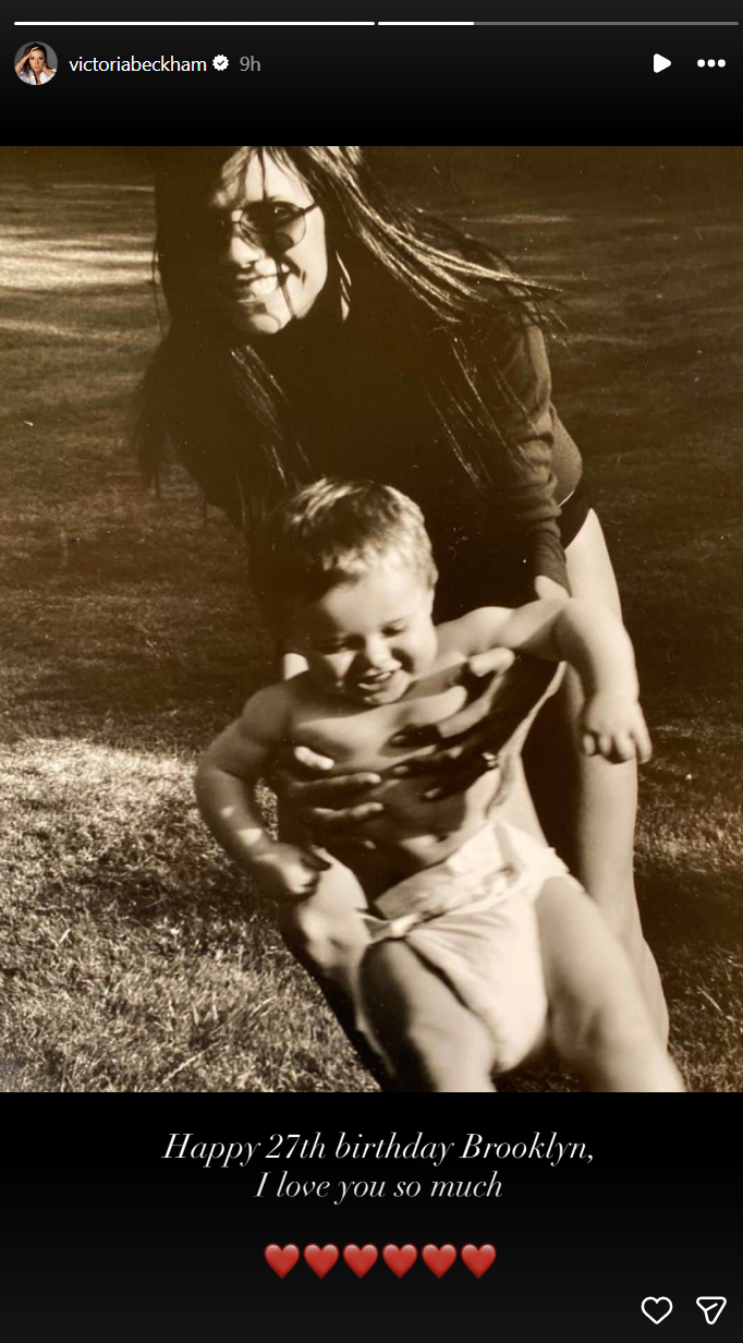 Sepia-toned photo of Victoria Beckham smiling and holding a baby on a grassy background, with text "Happy 27th birthday Brooklyn, I love you so much."