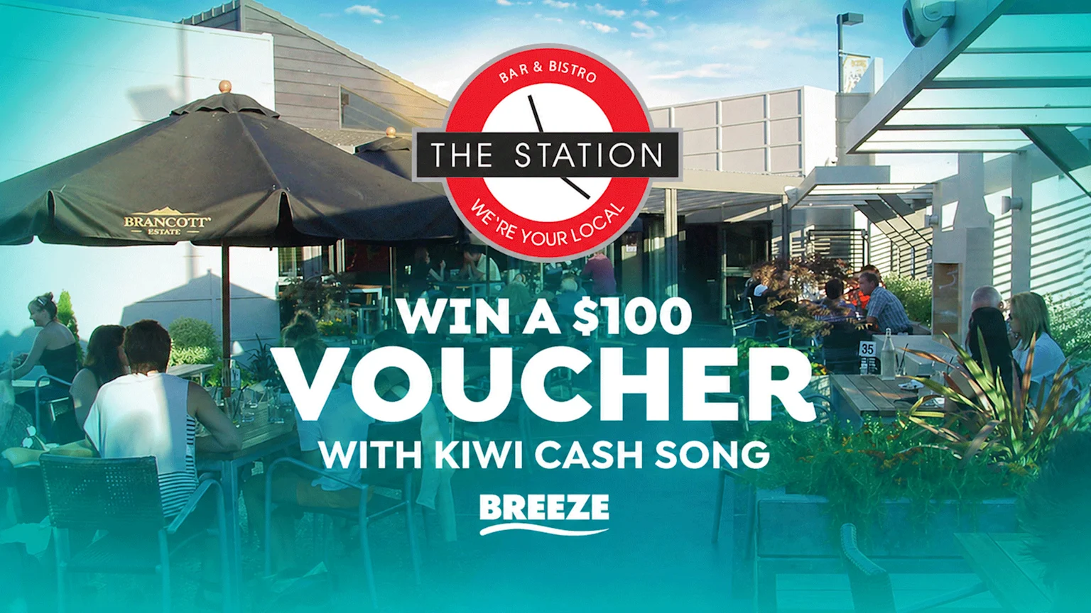 An outdoor patio scene at "THE STATION" bar and bistro, with people dining at tables under umbrellas, and a text overlay announcing "WIN A $100 VOUCHER WITH KIWI CASH SONG BREEZE".