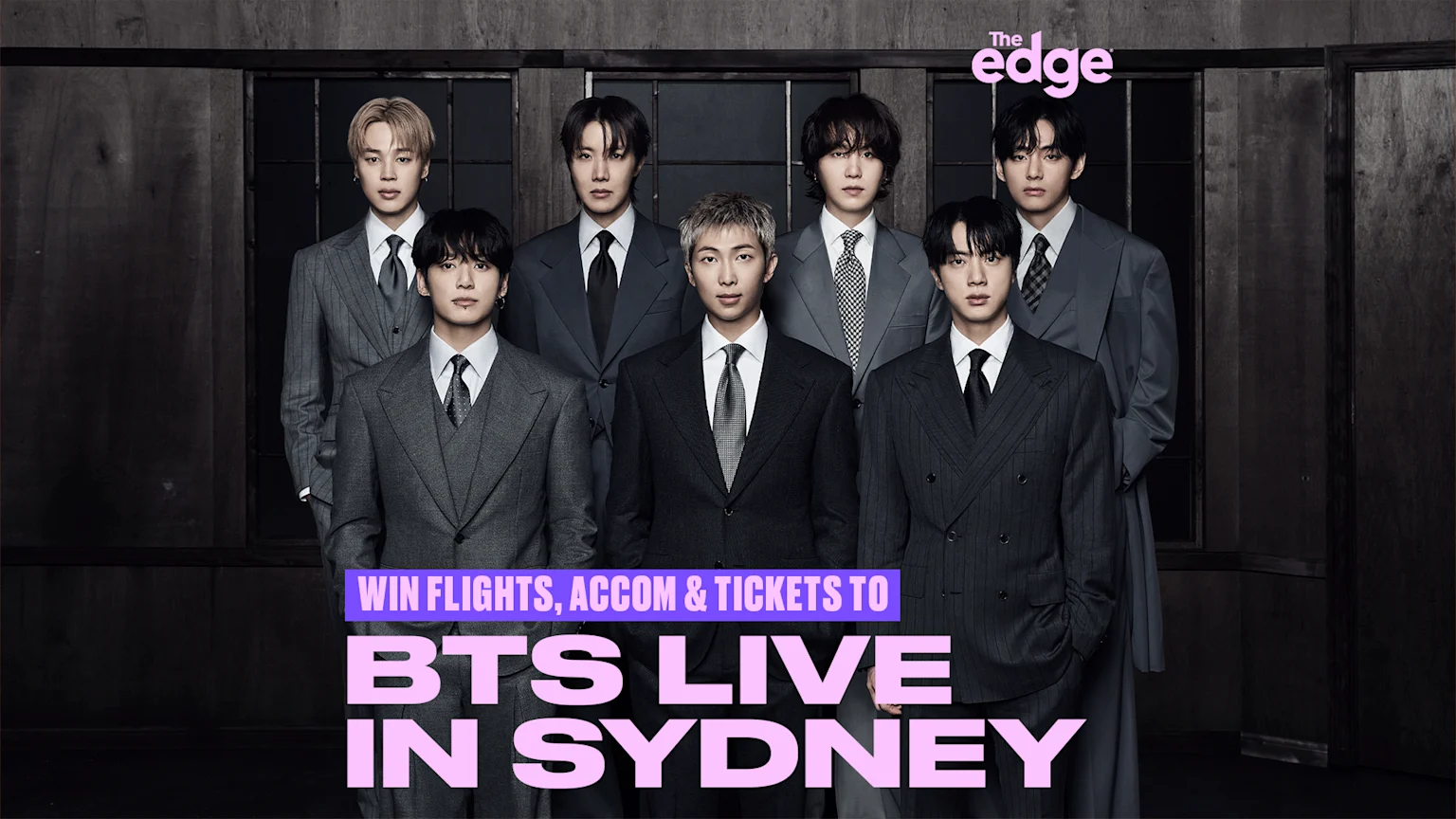 Seven members of the K-pop group BTS, dressed in suits, stand in a dark room, with promotional text for 'BTS LIVE IN SYDNEY'.