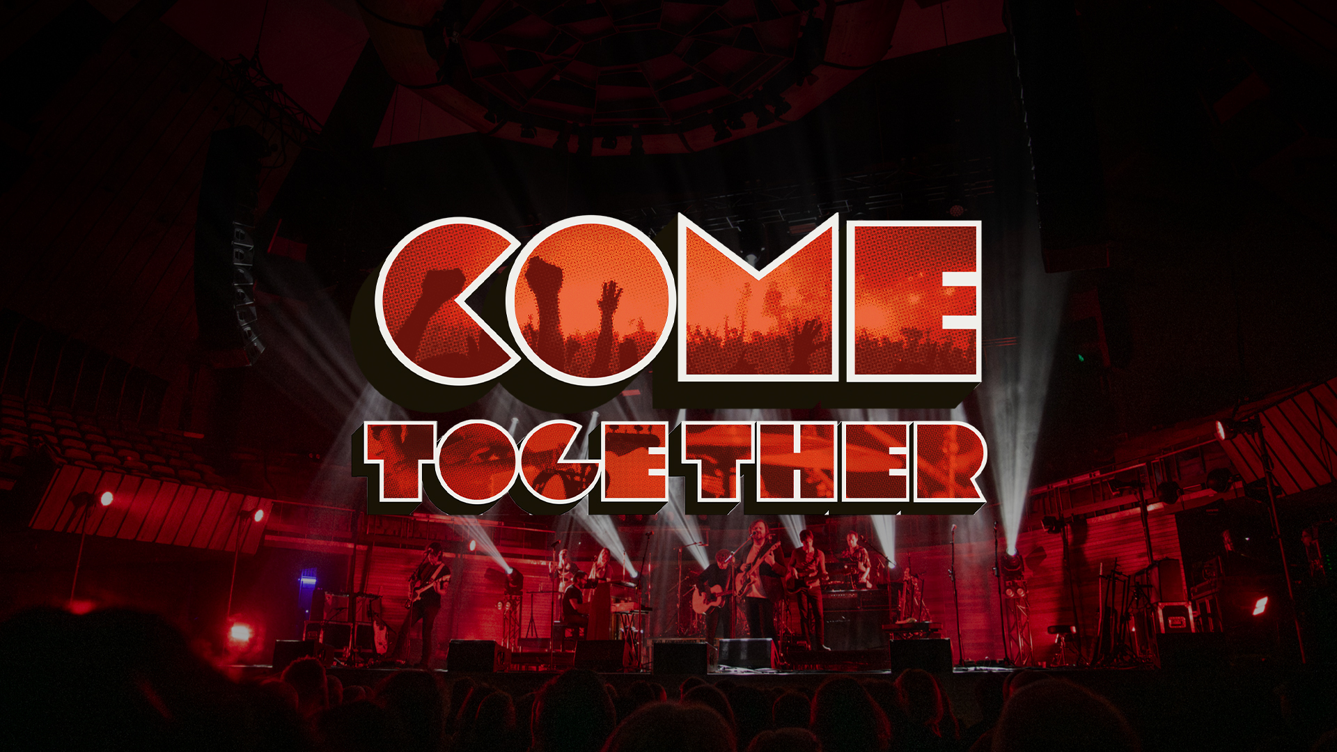 A live indoor concert shows a band performing on a large stage illuminated by red and white lights with guitars, keyboards, and drums visible. The audience appears in the foreground as dark silhouettes. Overlaid text "COME TOGETHER" with letters filled by images of raised fists and a crowd emphasizes themes of unity or protest.