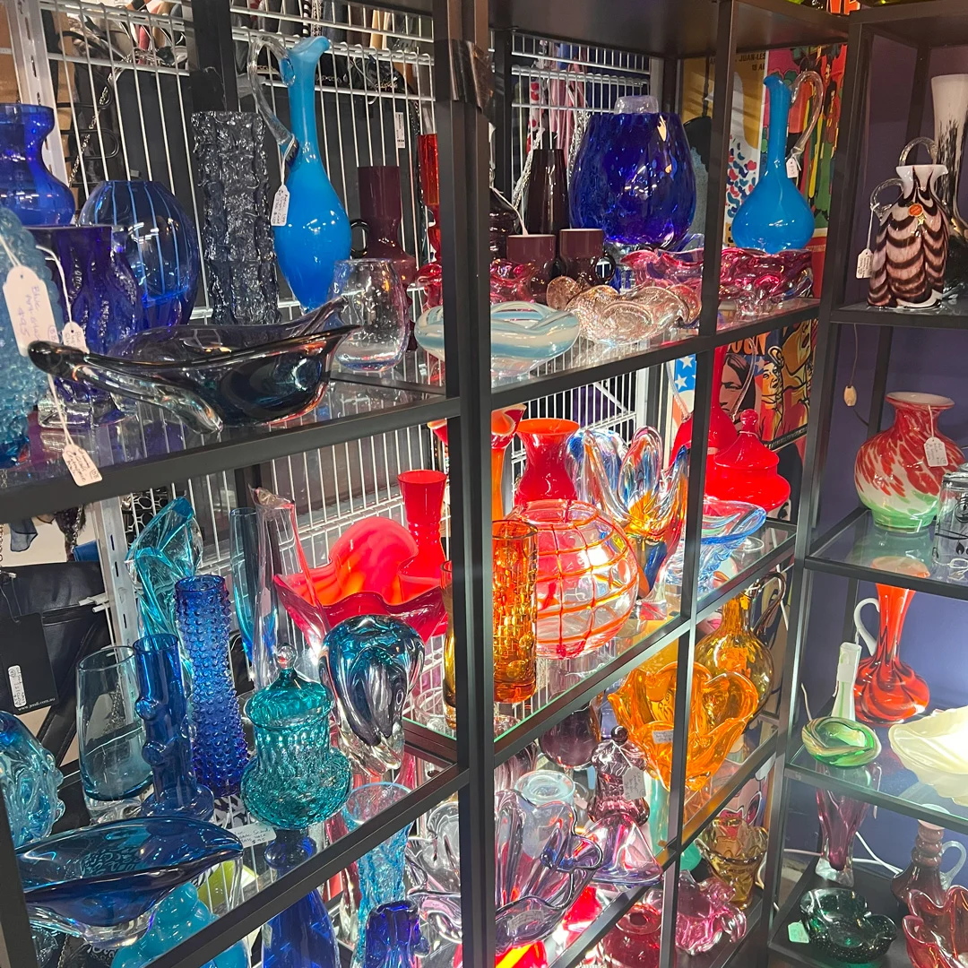 Colourful glass vases in display cabinet