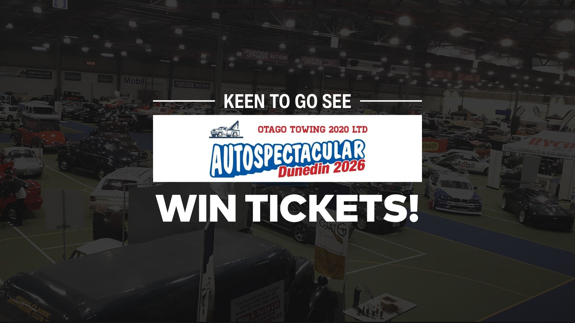 An indoor view of an autoshow with numerous cars, people, and booths, featuring a prominent overlay with "OTAGO TOWING 2020 LTD AUTOSPECTACULAR Dunedin 2026" and "WIN TICKETS!".
