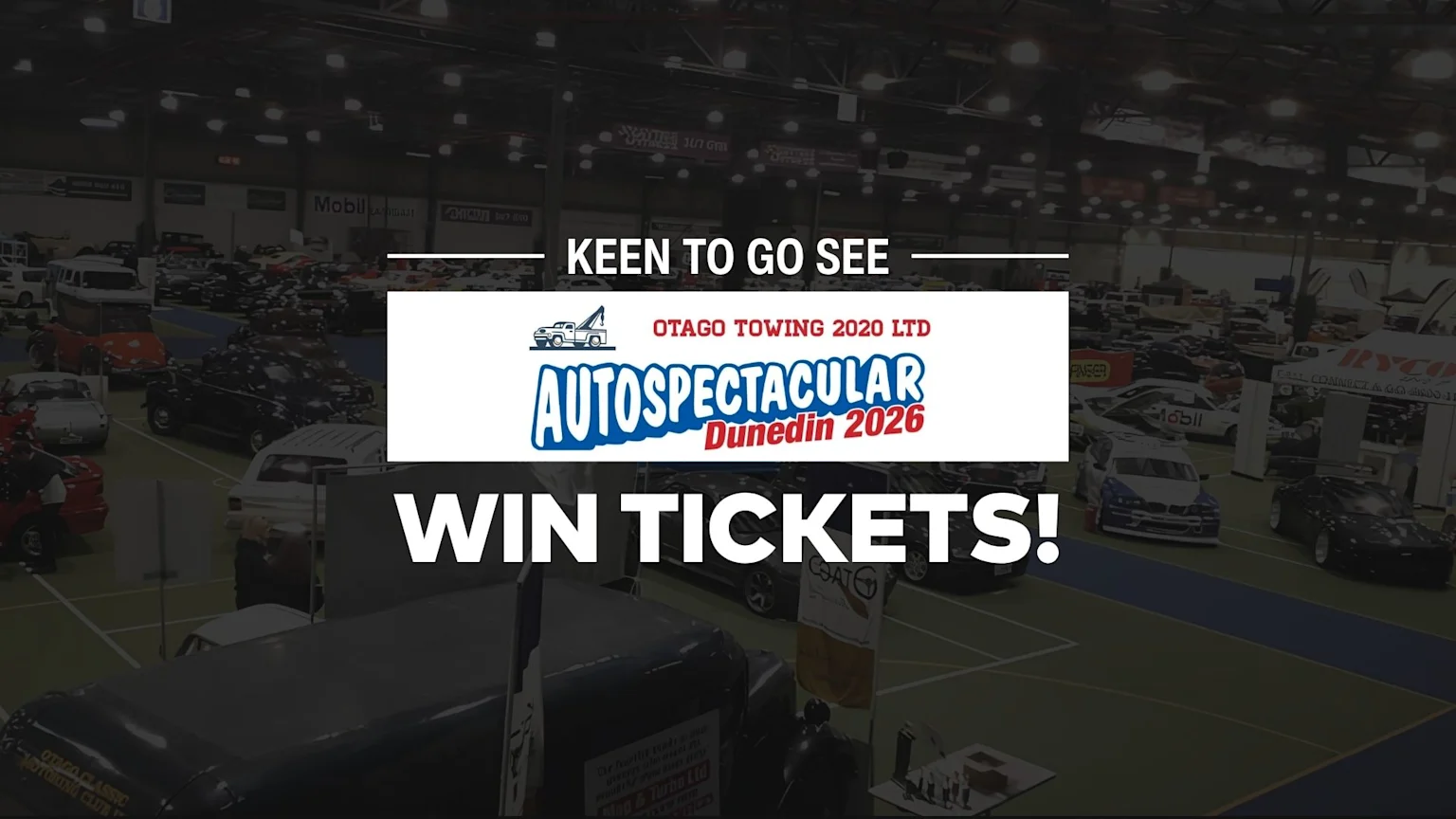 An indoor view of an autoshow with numerous cars, people, and booths, featuring a prominent overlay with "OTAGO TOWING 2020 LTD AUTOSPECTACULAR Dunedin 2026" and "WIN TICKETS!".