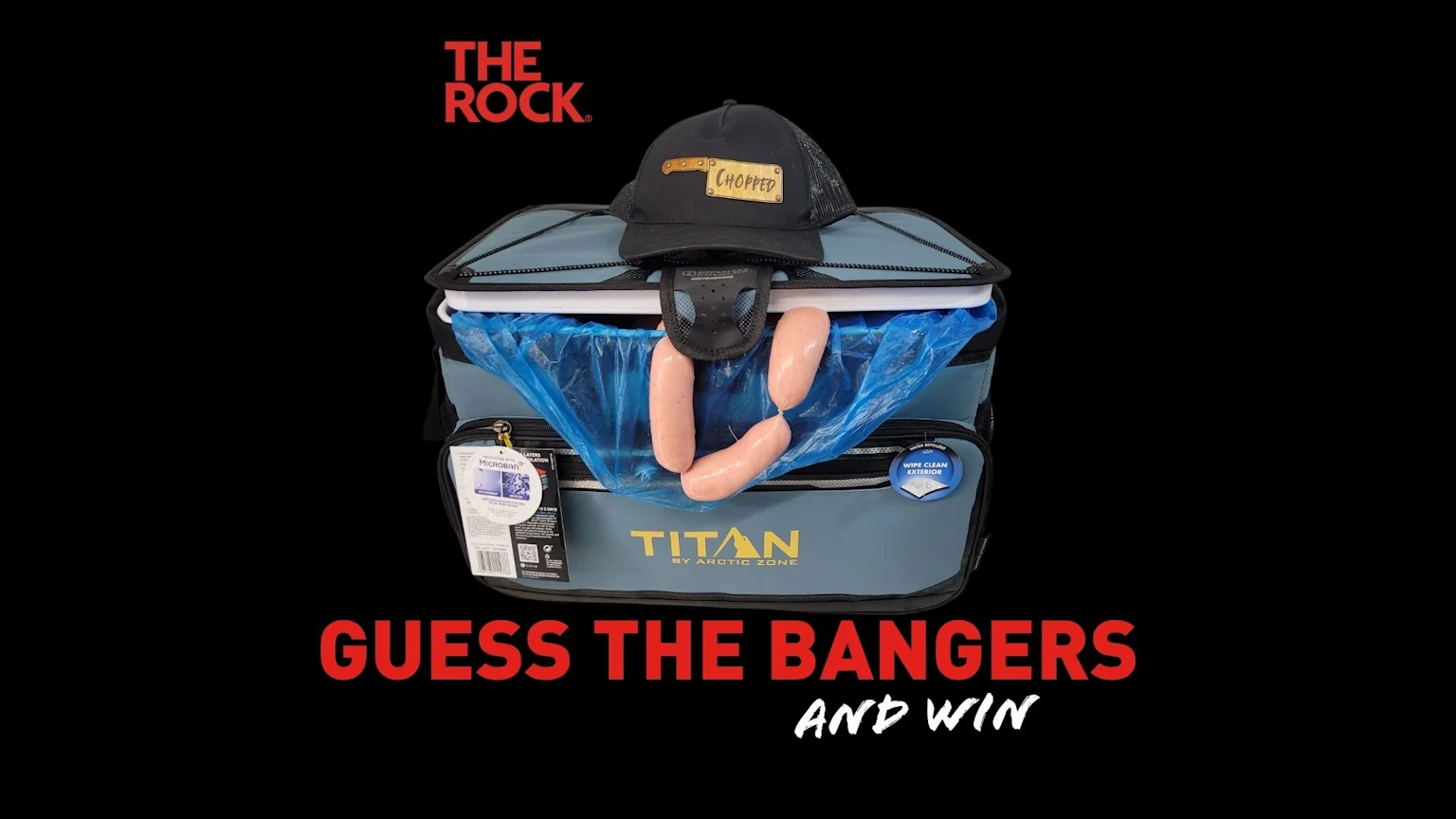A "Titan by Arctic Zone" cooler with a "Chopped" cap rests on top, three raw sausages hang from a blue bag inside, with "Guess The Bangers And Win" text below and "The Rock" logo above.