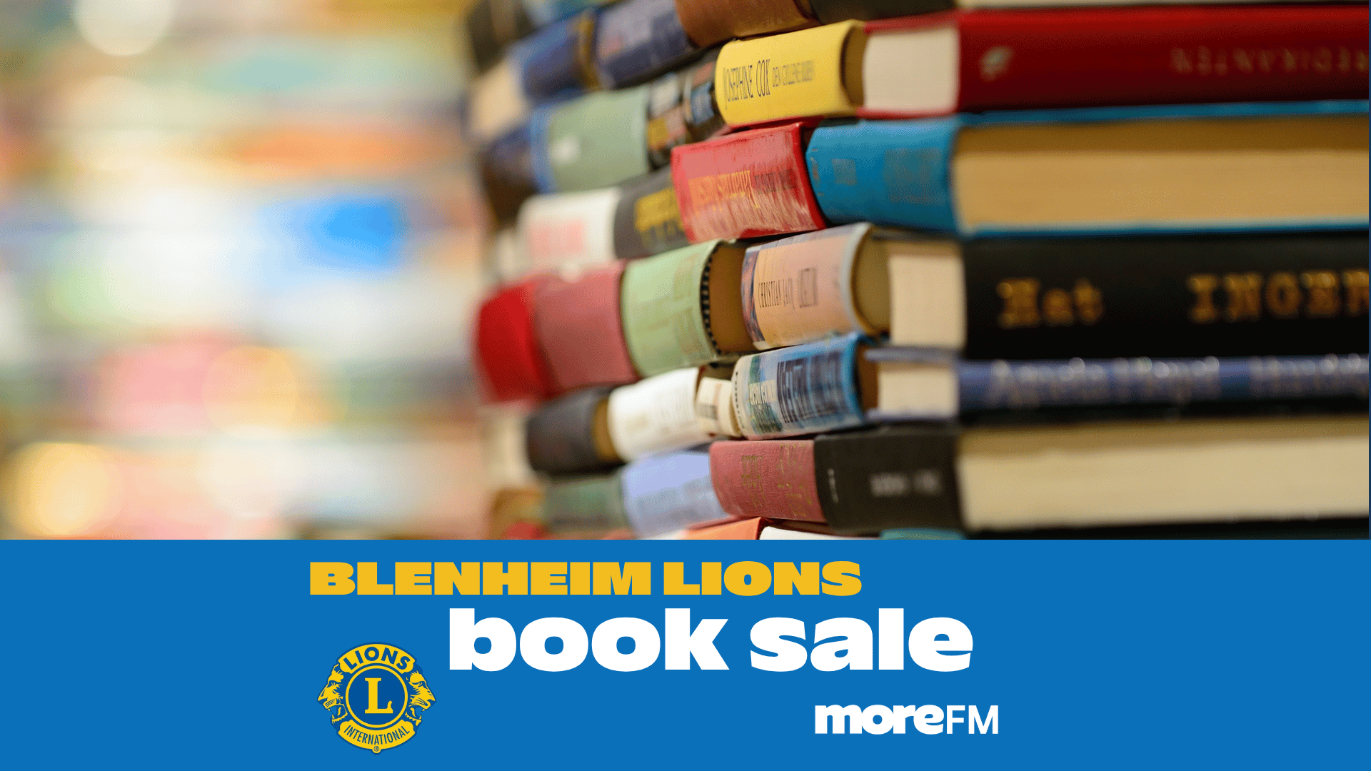 A colorful stack of books is shown against a blurred background, with a blue banner below reading "BLENHEIM LIONS book sale" alongside the Lions International and moreFM logos.