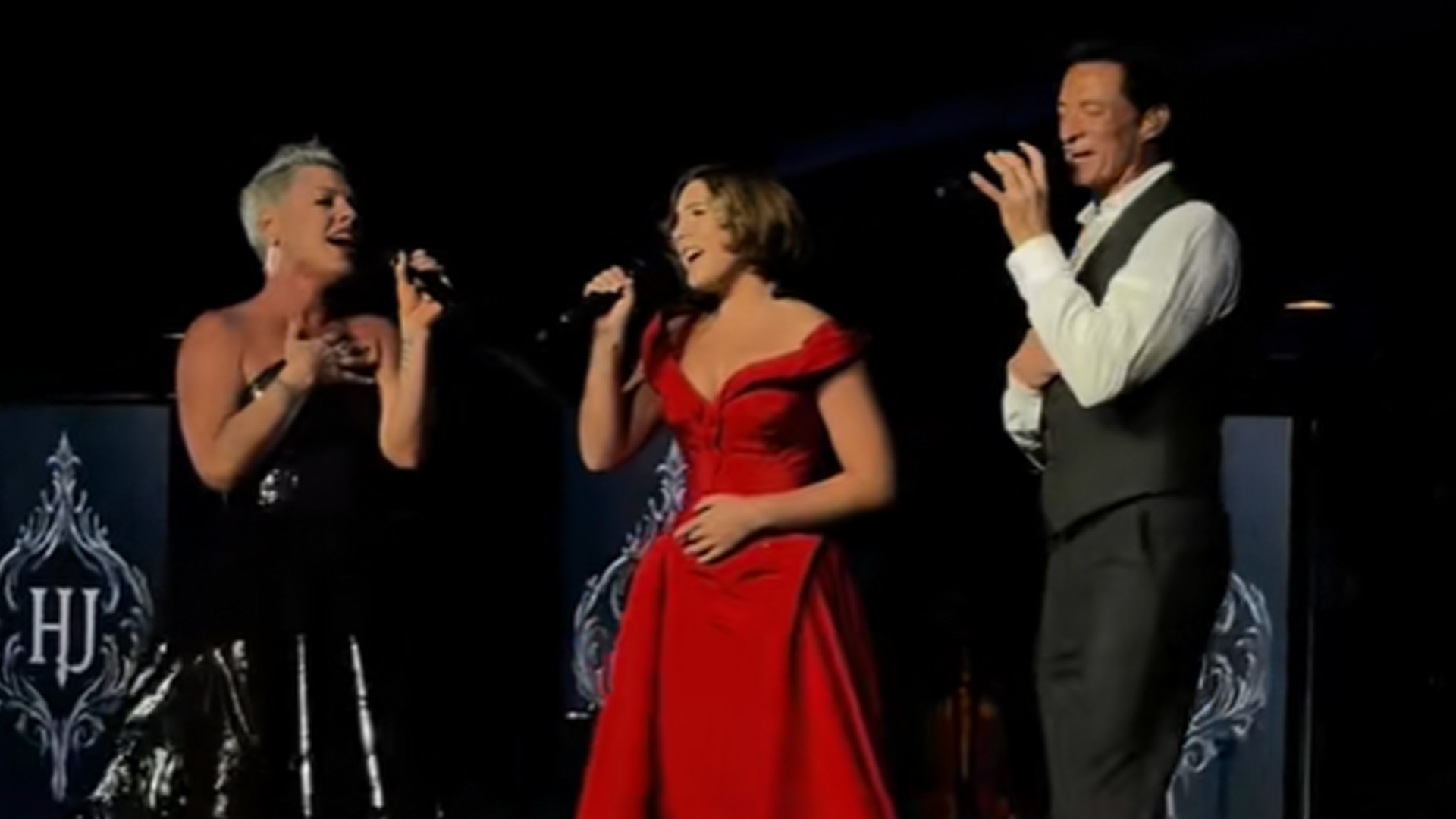 Pink (Left), Daughter Willow (middle), and Hugh Jackman (Right) singing on stage.