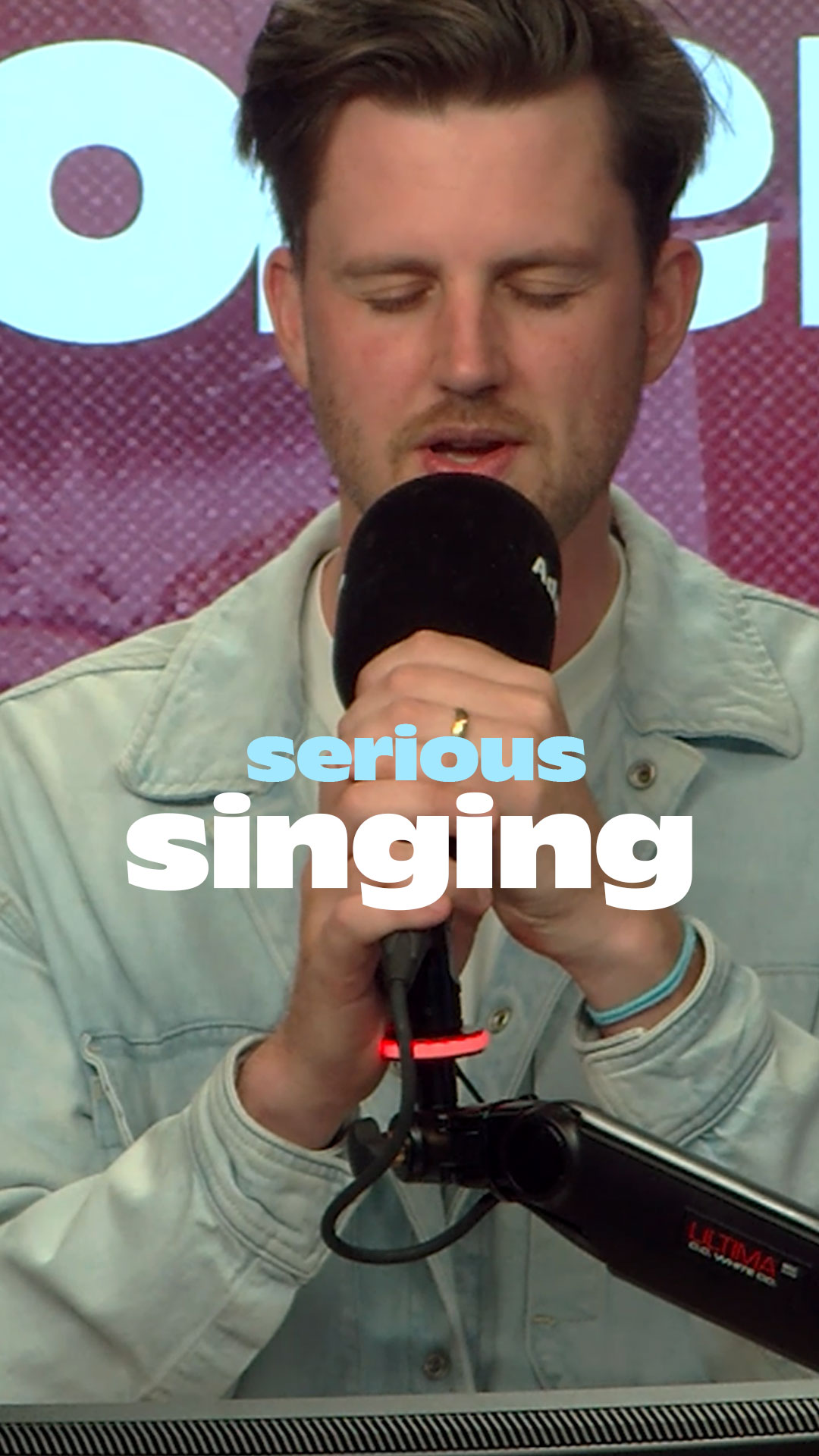 Adam holding microphone singing