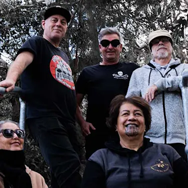 Salmonella Dub members sit on steps, leaning on metal railings