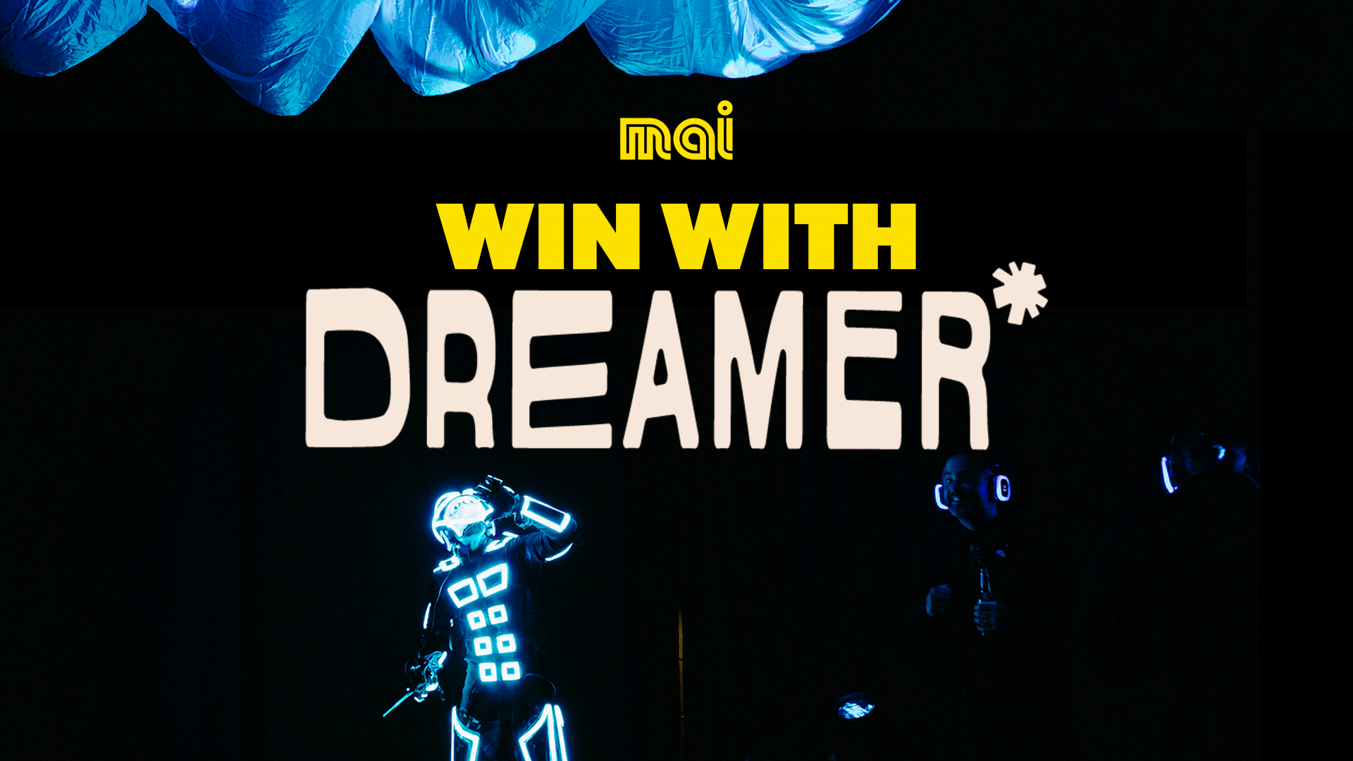 Text "WIN WITH DREAMER*" and mai logo, with two performers in glowing blue suits on a dark stage, and blue fabric overhead.