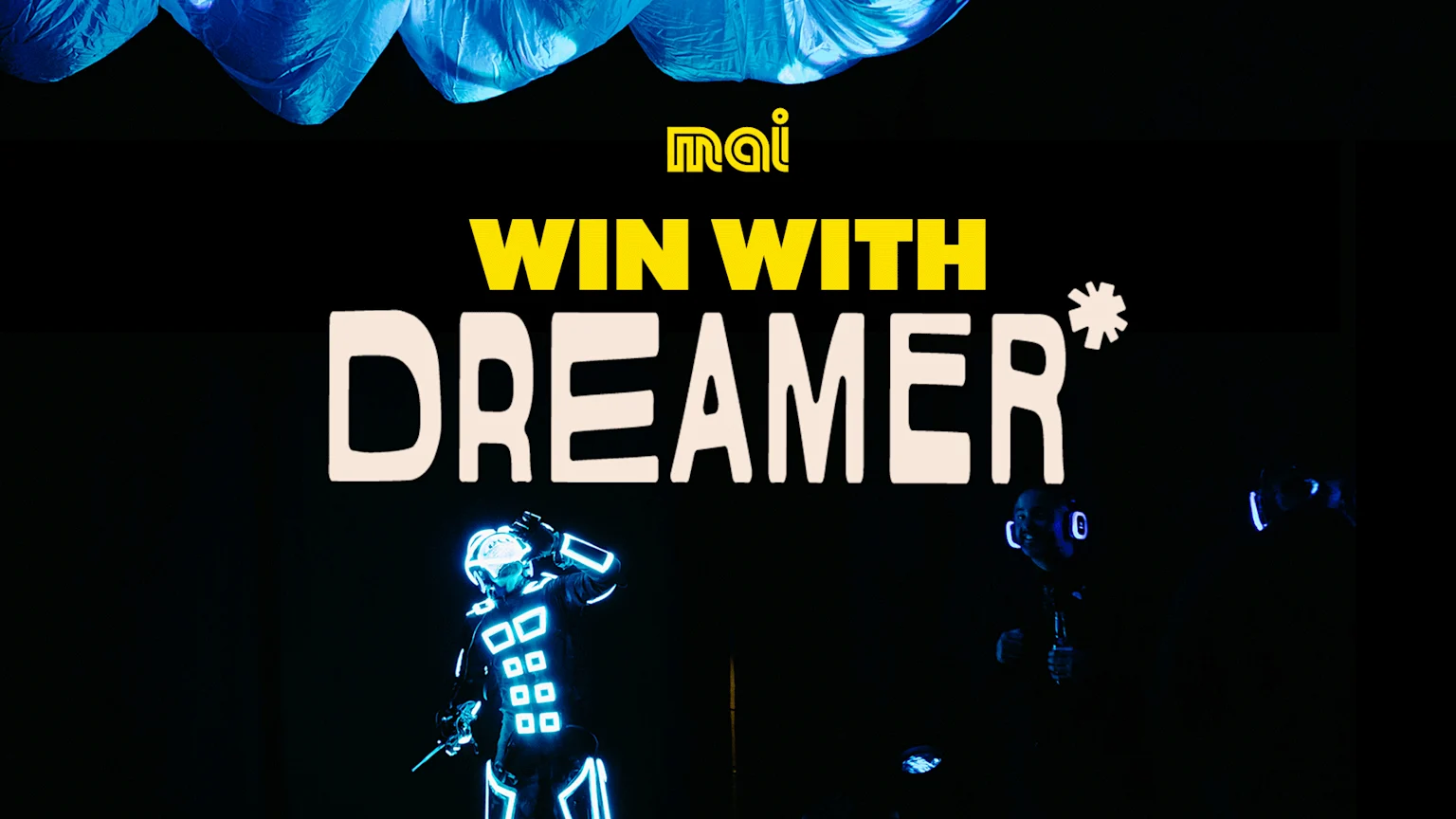 Text "WIN WITH DREAMER*" and mai logo, with two performers in glowing blue suits on a dark stage, and blue fabric overhead.