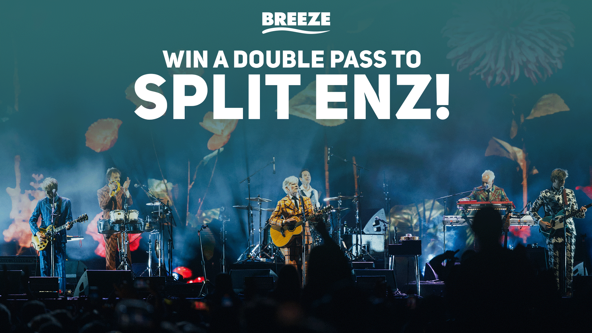 A band performs on a stage with hazy floral projections, observed by an audience, with overlaid text that reads "WIN A DOUBLE PASS TO SPLIT ENZ!" and the "BREEZE" logo.