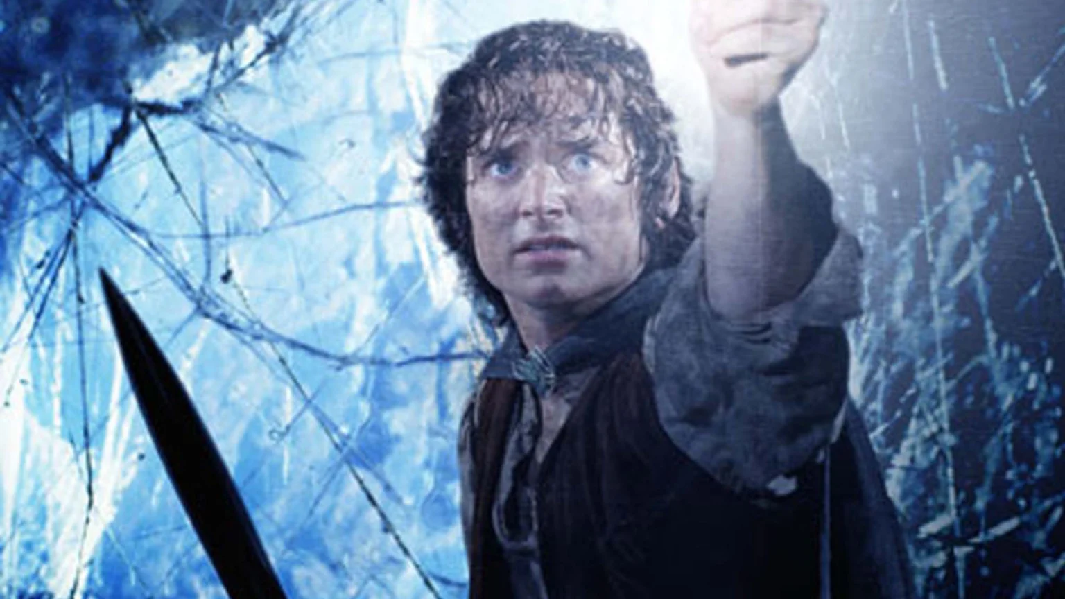 Elijah Wood as Frodo Baggins, wide-eyed and fearful, holds up a glowing object against a swirling blue background, with the tip of a dark sword in the foreground.