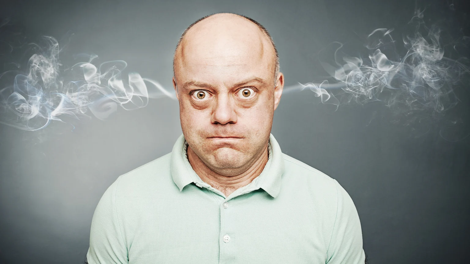 Picture of angry man with smoke blowing out of his ears.