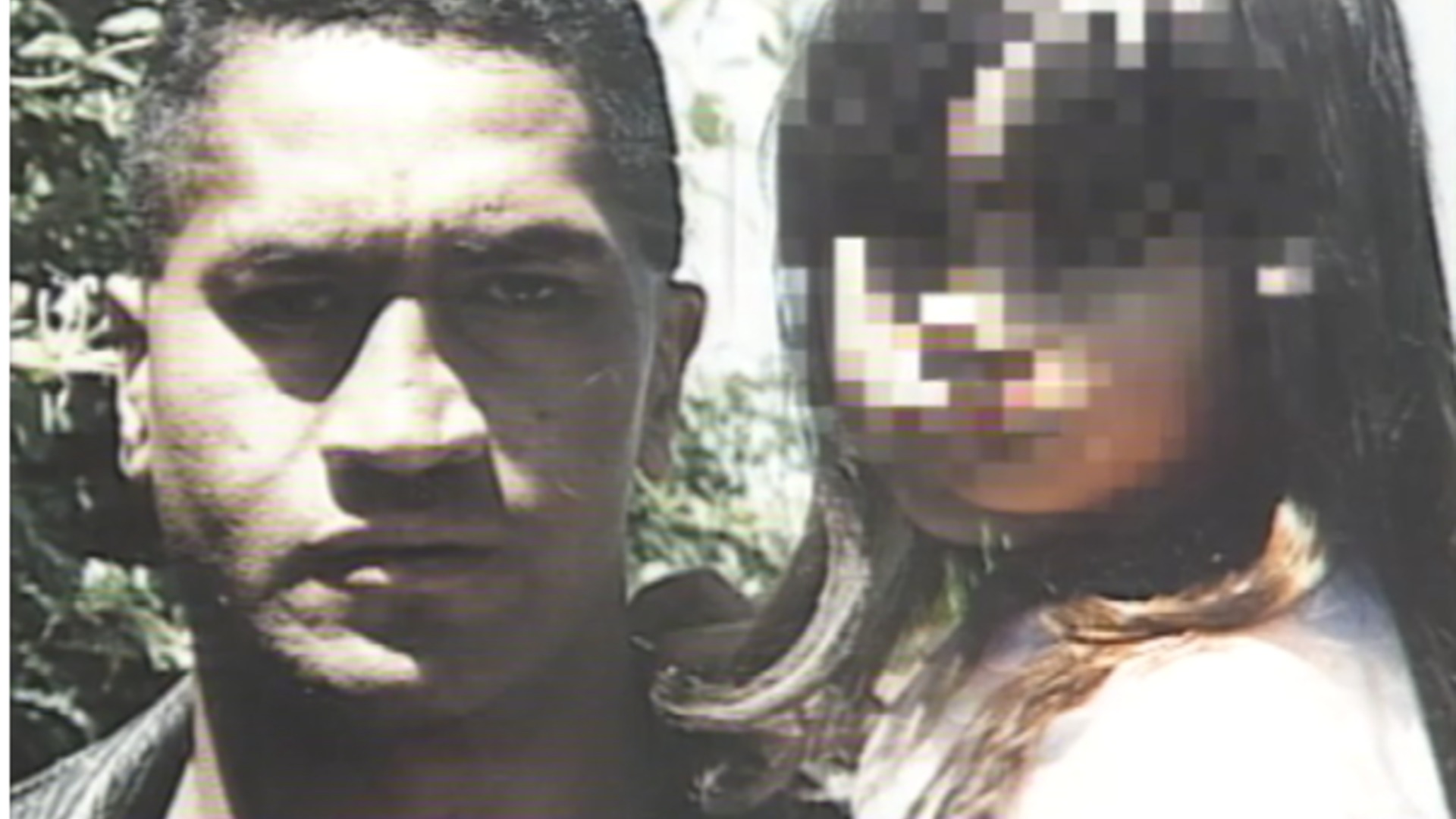 A grainy photo shows a man with dark hair and shadowed eyes looking forward, beside a young girl with long dark hair whose face is heavily pixelated; greenery in the background.