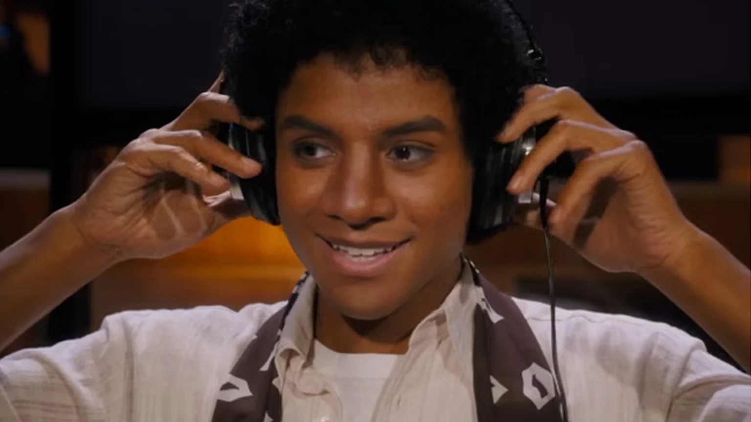 Jaafar Jackson portraying his uncle Michael Jackson in new biopic 'Michael'. Scene of him in a music studio putting headphone over his ears.