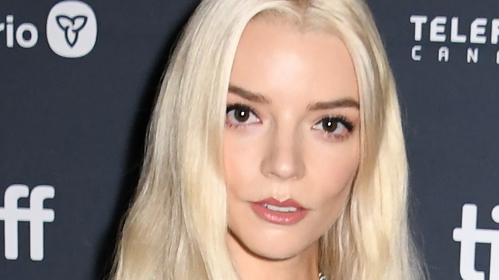 Close-up of Anya Taylor-Joy with long blonde hair and dark eyes, gazing directly at the camera. Blurred logos for 'TIFF' and 'Telefilm Canada' appear in the dark background.