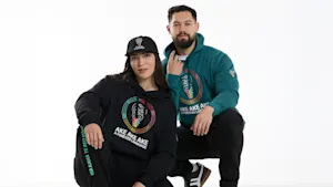 Two people wearing Māori language week hoodies