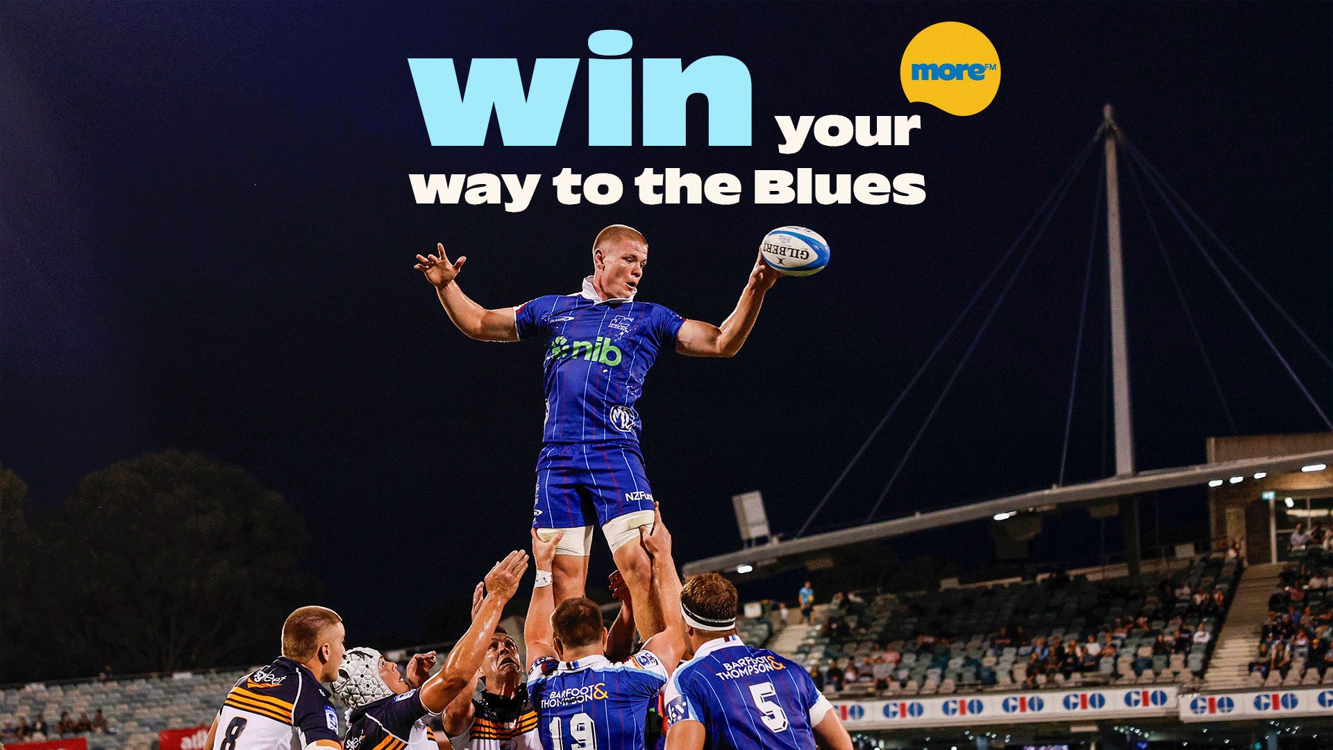 A rugby player in a blue jersey is elevated by teammates during a line-out, holding a ball, on a floodlit stadium field at night with text overlay "win your way to the Blues".
