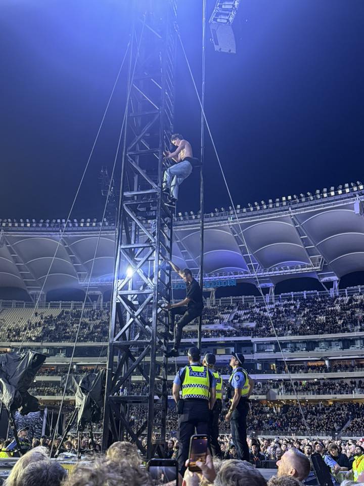 Two men climbing a tower, police waiting for them at the bottom