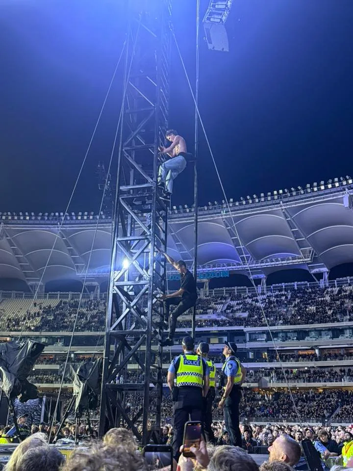Two men climbing a tower, police waiting for them at the bottom