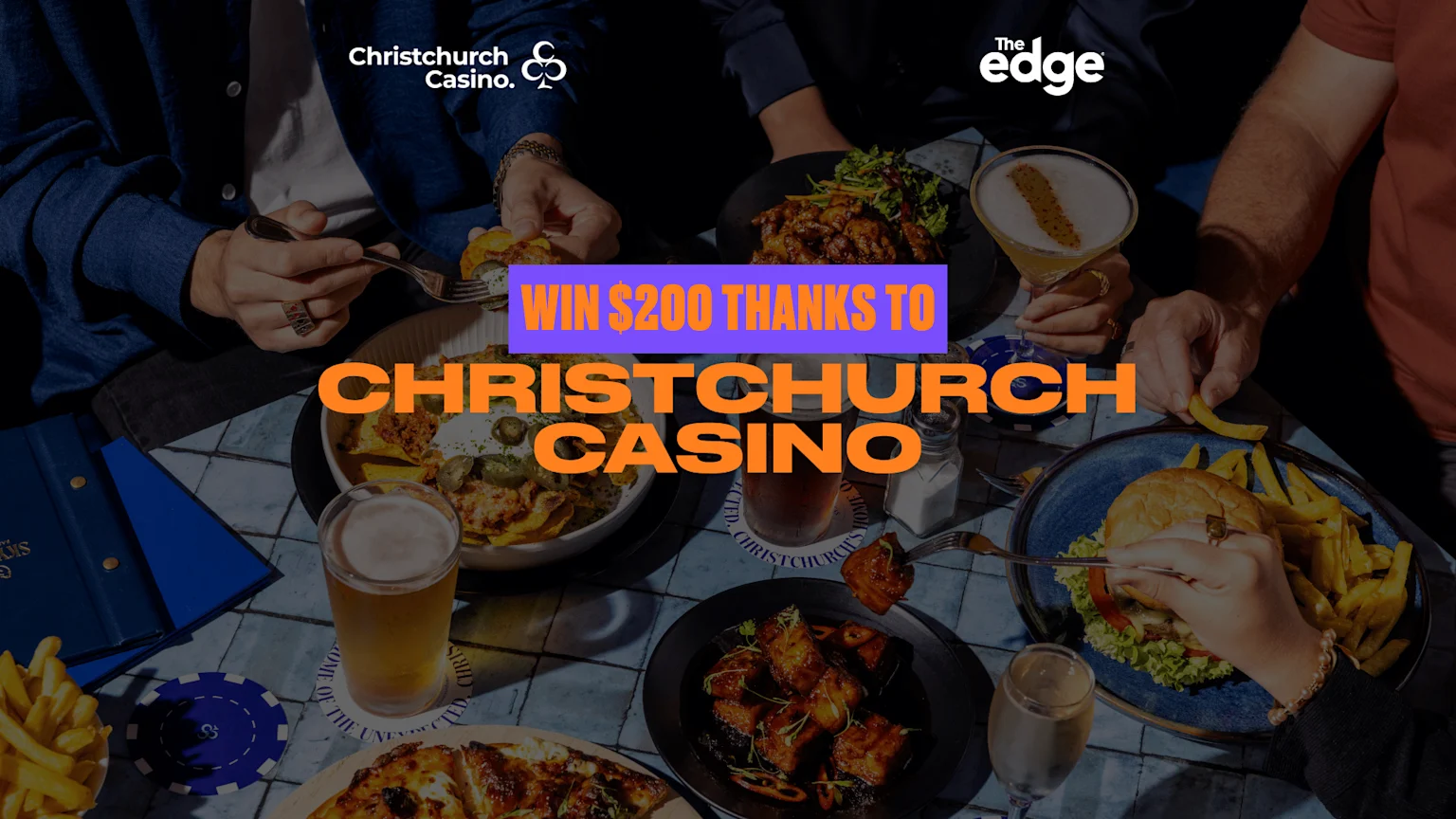 An overhead view of people sharing a meal and drinks at a table, featuring food, beverages, and prominent text "WIN $200 THANKS TO CHRISTCHURCH CASINO" along with Christchurch Casino and The Edge logos.