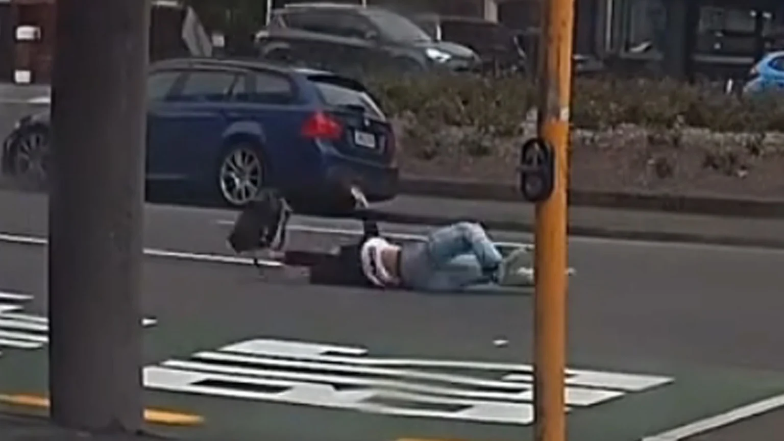 Severe wind in Wellington, NZ pushes pedestrian to fall on road in front of traffic.