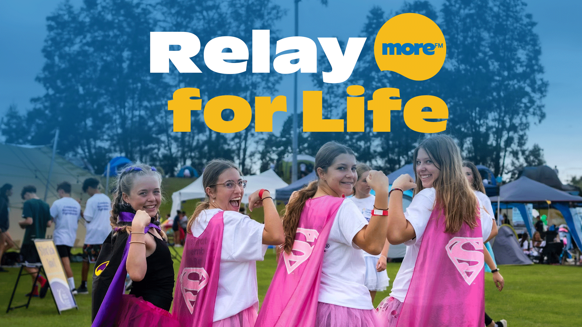 Four smiling young women in superhero capes and tutus pose at an outdoor Relay for Life event with tents in the background and "Relay for Life" text overlay.