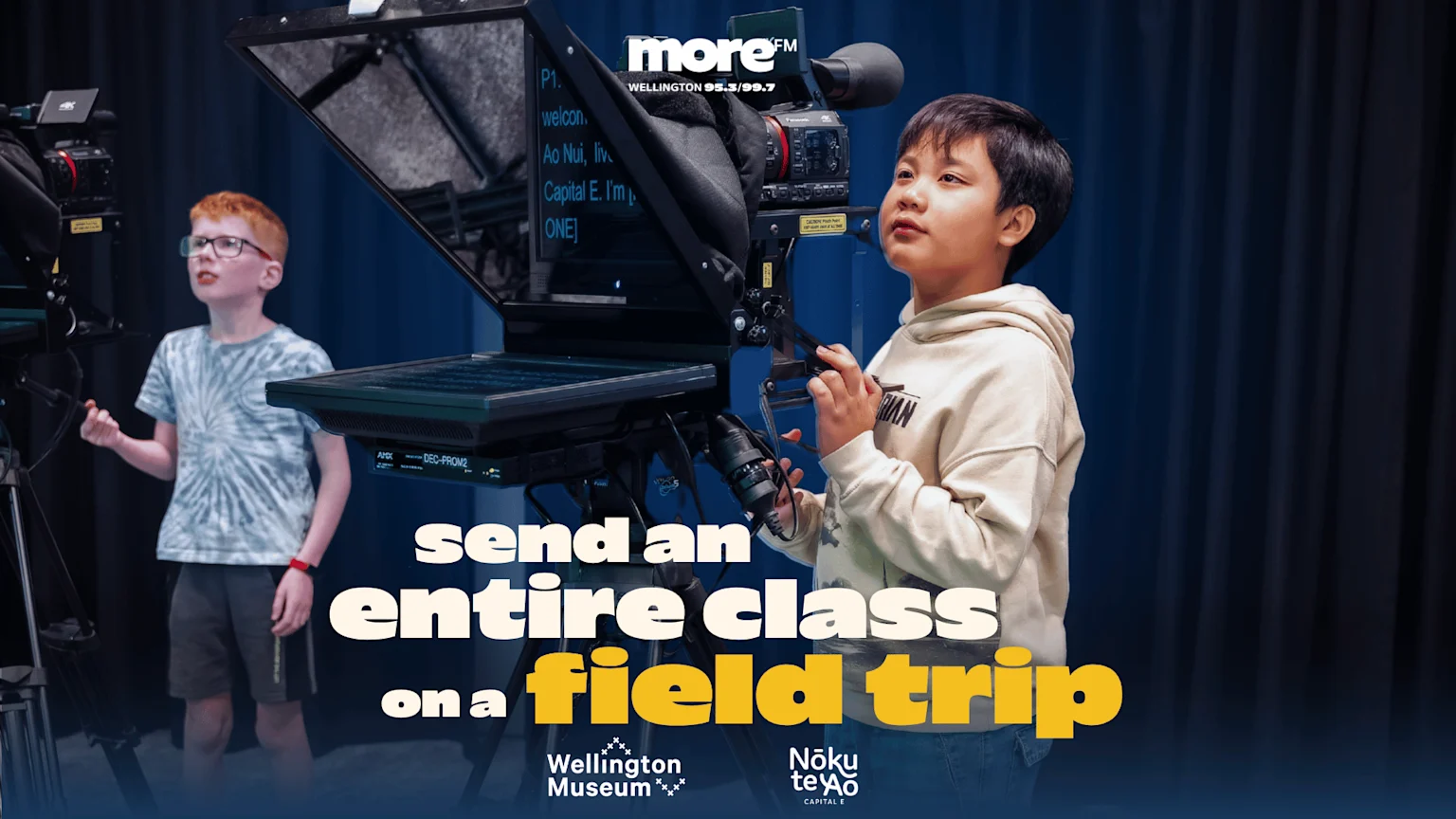 Two children are in a studio, one operating a camera with a teleprompter, the other standing by a camera, with "send an entire class on a field trip" text.