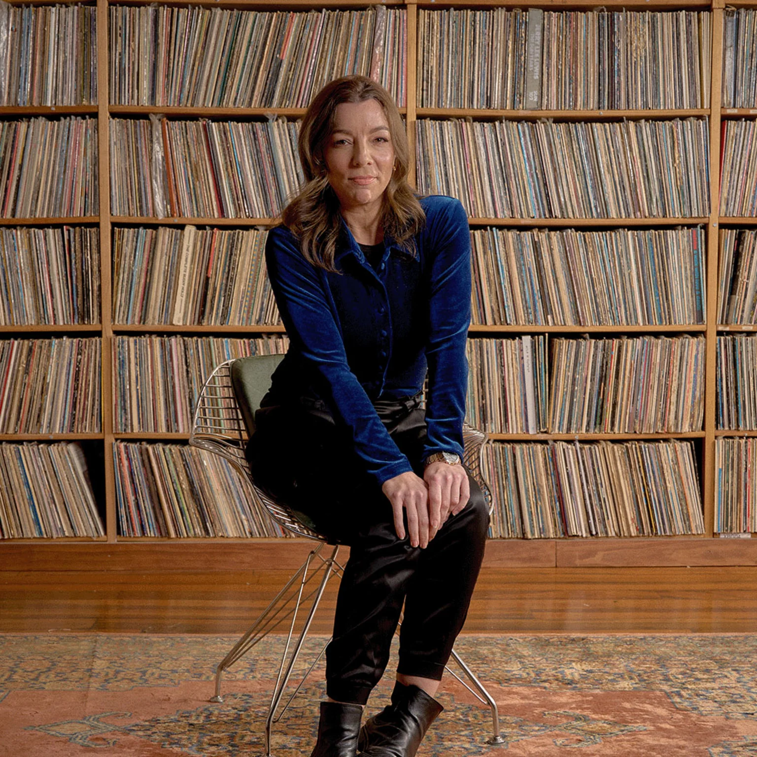 Georgia Cubbon sits in front of vinyl record collection
