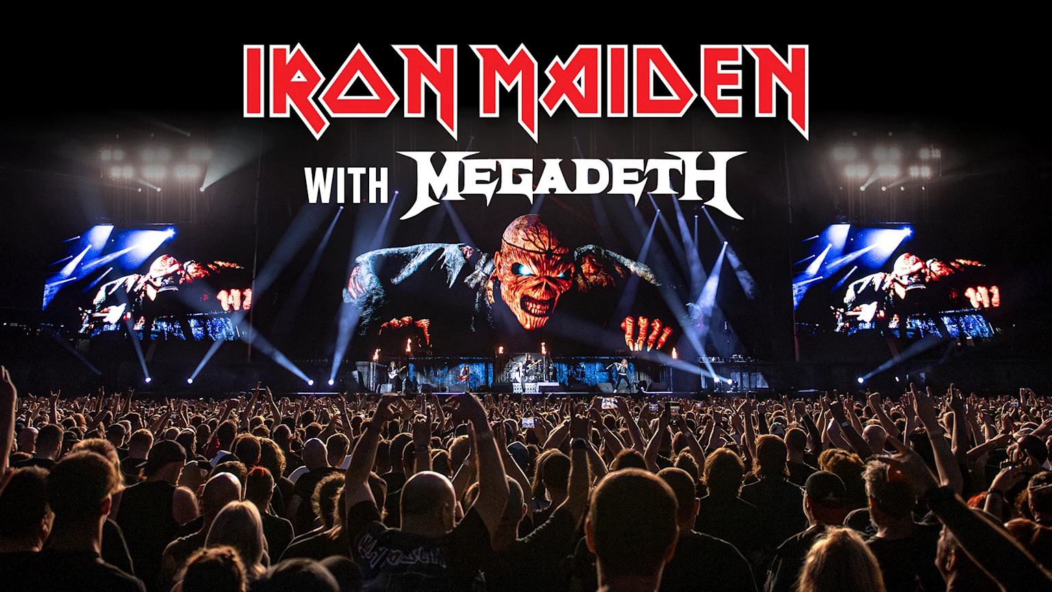 A large crowd faces a concert stage where Iron Maiden and Megadeth logos are displayed above a screen showing Iron Maiden's mascot, Eddie, with performers below and bright lights.