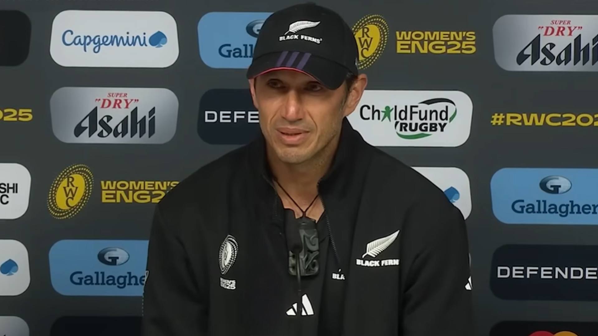 Black ferns coach talking at a press conference.